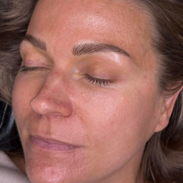 Close-up of a woman with closed eyes and a neutral expression after getting nano brows done in Grimsby clinic.