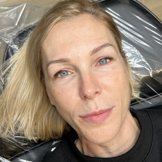 Close-up of a woman with healed winged eyeliner tattoo on her upper lash line. The eyeliner follows her natural eye shape and adds soft lift to her hooded eyes.